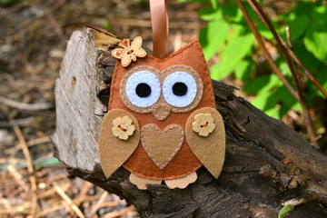 Felt owl toy on a branch. Felt soft bird toy outdoor, kids crafts. DIY concept