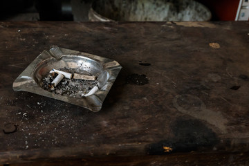 Butt cigarette , ashtray on a  grunge wooden table