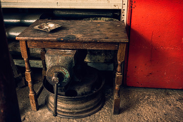 Ashtray on a  grunge wooden table in a junkyard with old mechani
