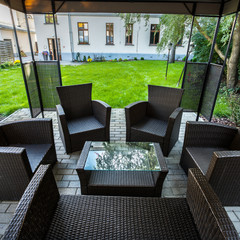 Wicker chairs on hotel's patio in garden