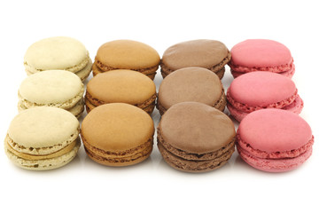 assorted freshly baked macarons on a white background