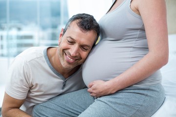 Man listening the belly of pregnant woman