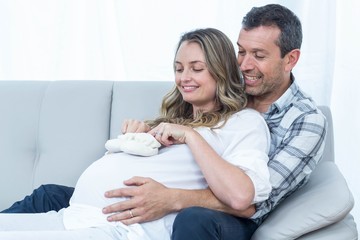 Pregnant couple sitting on sofa