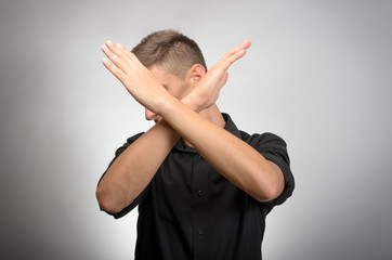 Young man making X shape for Extreme with his hands.