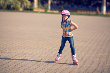 Attractive teenage girl roller skating in the park.