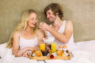 Cute couple having breakfast in bed