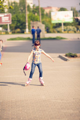 Attractive teenage girl roller skating in the park.