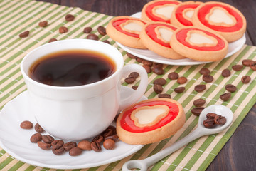 coffee cup with beans and cookies on the wooden table