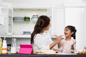 Indian mother and daughter having fun when cooking