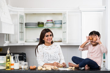 Indian mother and daughter enjoying cooking together