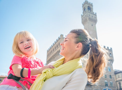 Portrait of smiling mother and daughter near Palazzo Vecchio
