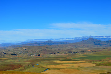 Drakensberg mountains with grass and trails and blue sky