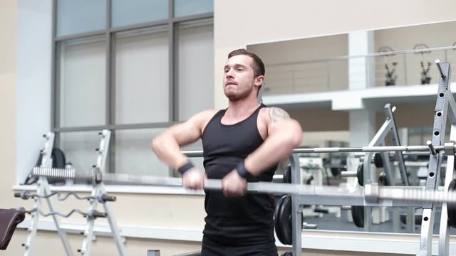 Young strong man hard train muscles in gym