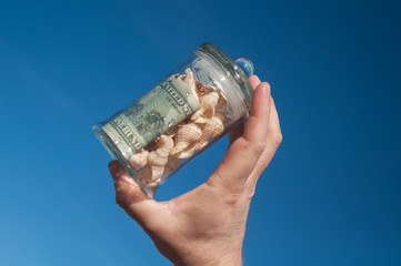 glass jar with money in hand