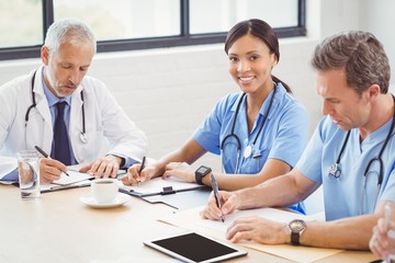 Medical team writing a report in conference room