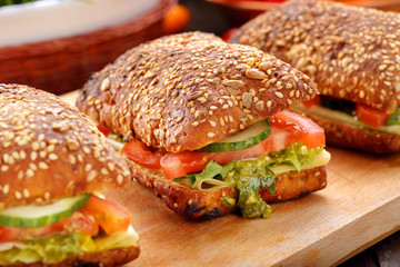 Vegetarian sandwich with pesto on wooden background