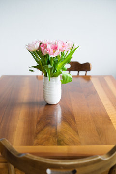 Tulips in blue vase on wooden table. Selective focus.