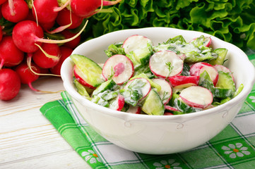 Spring vegetable salad with radish, cucumbers, greens and natural yogurt.