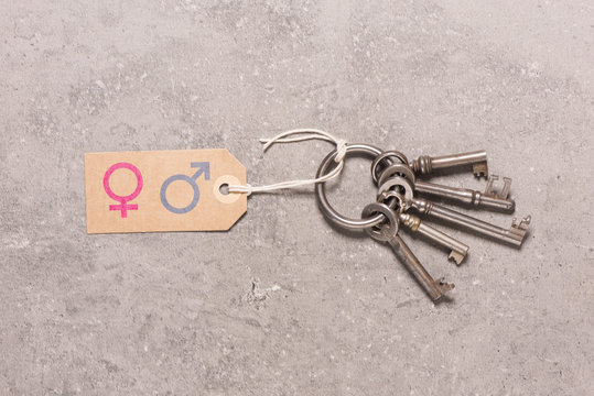Keys and paper tag with female and male symbol. Concept of gender, relationship and living together.