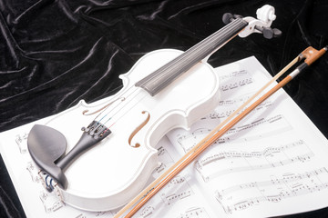 White violin isolated on black background with notes