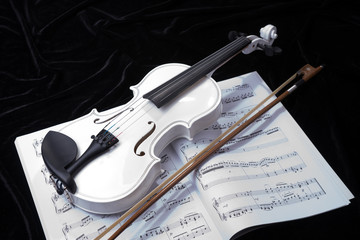 Naklejka premium White violin isolated on black background with notes