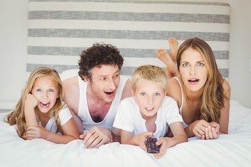 Family relaxing on bed at home