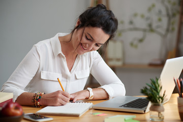 Smiling business woman writing down her ideas