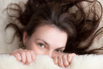 Beautiful woman lying in bed and looking at camera