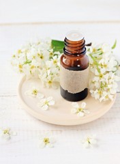 Floral refreshing aromatherapy. Bottle of cosmetic aroma oil and blossom. 