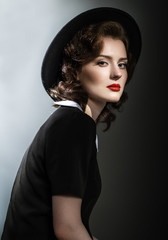 Retro classic portrait of elegant woman in black hat and dress