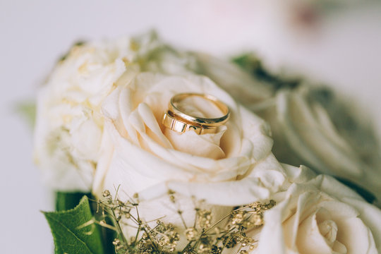 Gold rings on a bouquet of roses
