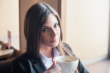 girl with unusual eyes in suit holding Cup of coffee