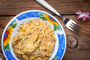 Fried cabbage greens and onion in wooden table.