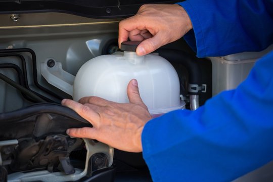 Mechanic Checking A Coolant Water Tank