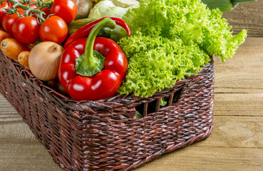 Wicker basket with fruits and vegetables on the table