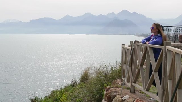 Beautiful girl standing on the waterfront in the background mountins. Beautiful girl standing on the waterfront in the background mountins..