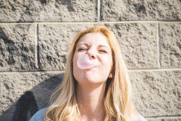 Young beautiful girl playing with bubblegum