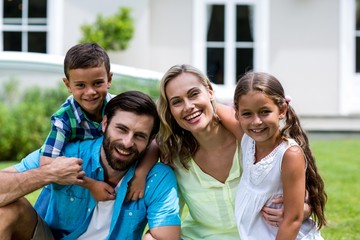 Portrait of happy family sitting in yard 