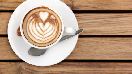 Overhead of cappuccino on wooden table