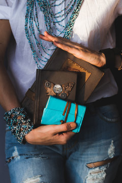 Woman holding several different notebooks in hands