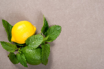 Yellow lemon, lime and green mint leaves on table. Top view