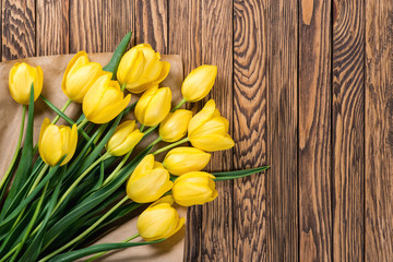 Fresh yellow tulips on wooden background
