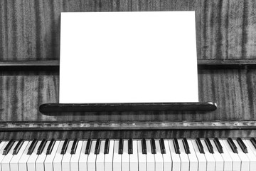 The old piano and sheet of white paper. Close-up view. White background for text and advertising.
