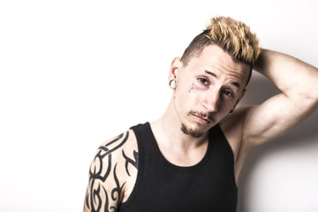 Handsome stylish young man with tattoo and piercing