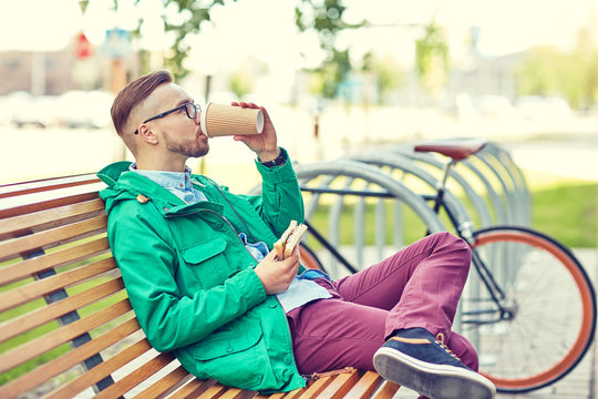 happy young hipster man with coffee and sandwich