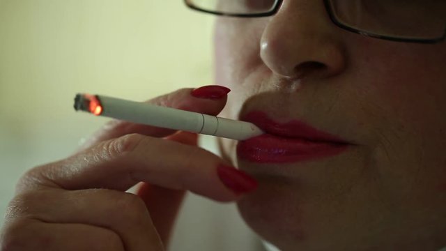 Woman smoks a cigarette. Woman with a cigarette. Female smoker, close up shot