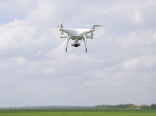 Fototapeta na wymiar Flying white quadrocopters over a field of wheat