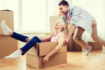 Fototapeta na wymiar couple with cardboard boxes having fun at new home