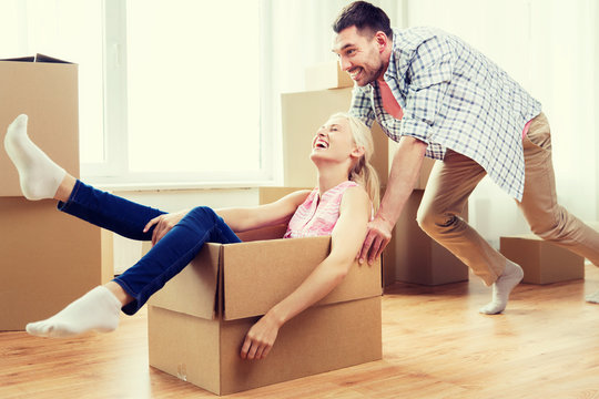 couple with cardboard boxes having fun at new home