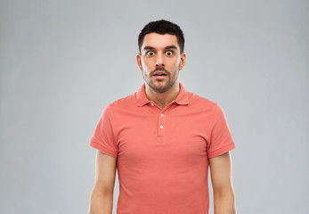 surprised man in polo t-shirt over gray background